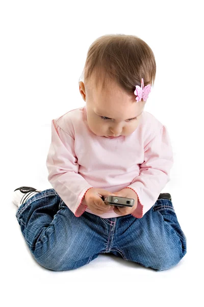 Het kleine meisje met een mobiele telefoon — Stockfoto