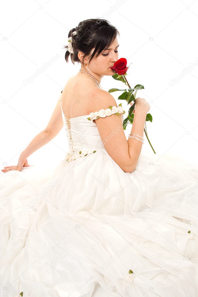 Bride sniffing a red rose