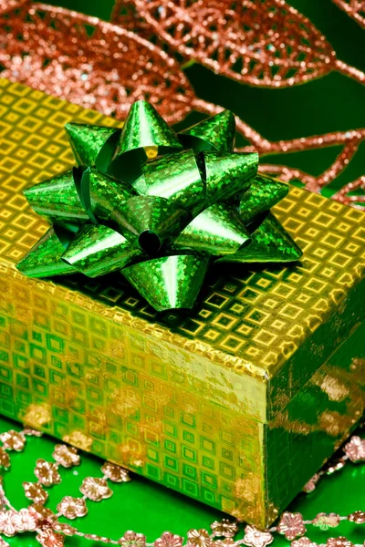 Зеленая подарочная коробка и листья — стоковое фото
