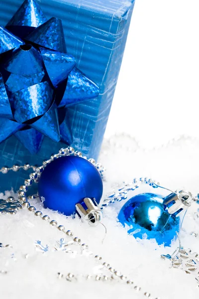 Palle festive con scatola regalo sulla neve — Foto Stock