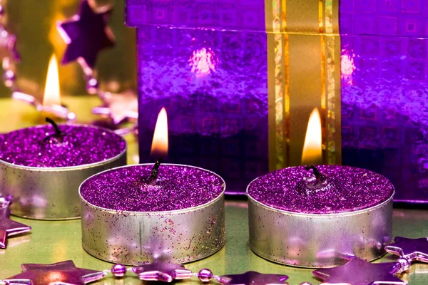 Caixa de presente violeta e vela acesa — Fotografia de Stock