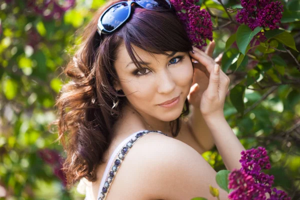Chica tierna en el jardín con lila —  Fotos de Stock