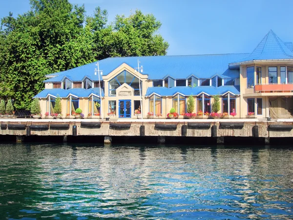 stock image Cottage on water with a blue roof