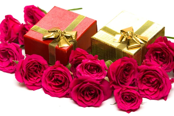Золотые подарочные коробки с красными розами — стоковое фото