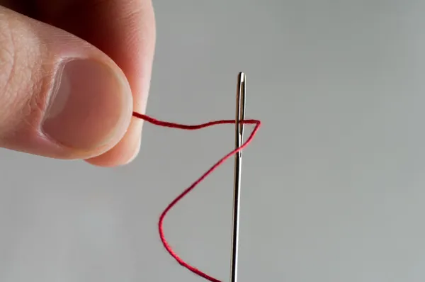 Thread through a needle — Stock Photo, Image