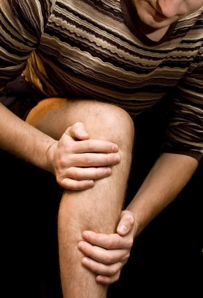 У молодого человека болит колено — стоковое фото
