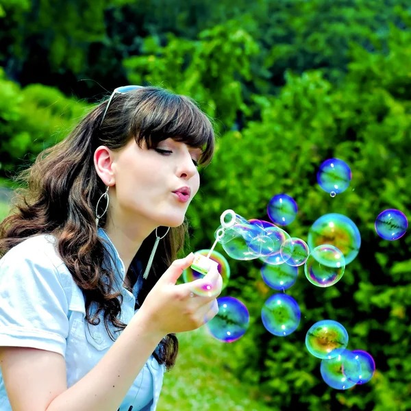 Chica joven soplando burbujas de jabón — Foto de Stock