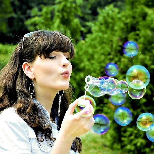 Young girl blowing soap bubbles — Stock Photo, Image