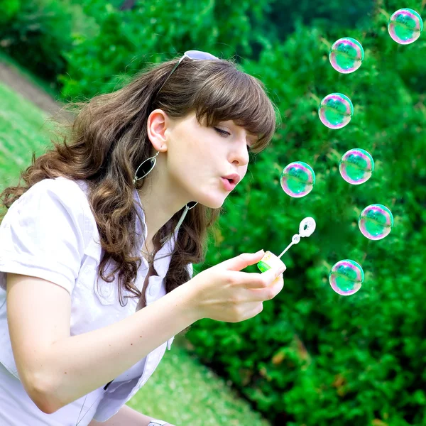 Sonrisa adolescente soplando burbujas de jabón — Foto de Stock