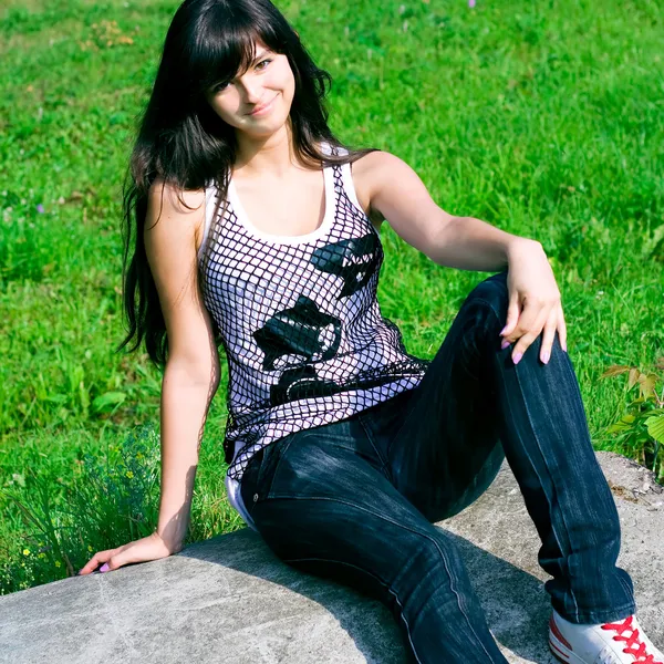 Smile tonåring sitter på stenen — Stockfoto