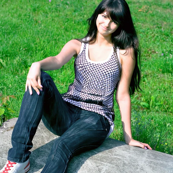 Sorria adolescente sentado na pedra — Fotografia de Stock