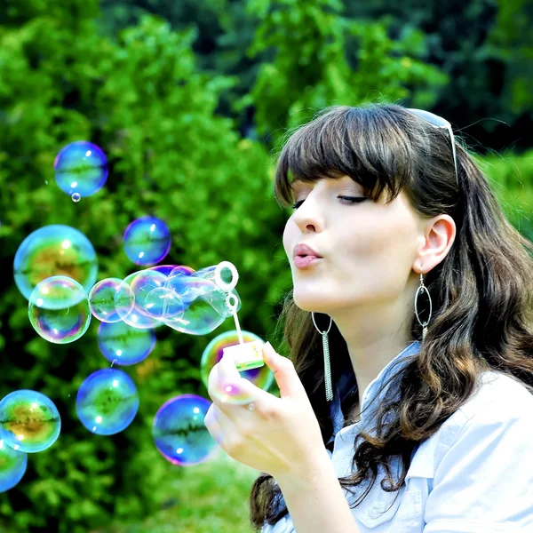 Chica joven soplando burbujas de jabón —  Fotos de Stock