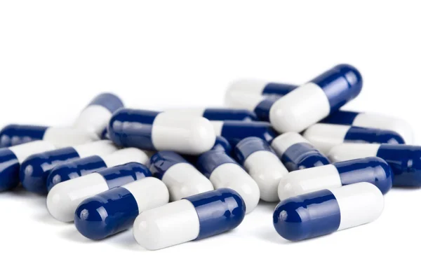 Niebieski i biały kapsułki tabletki na białym tle — Zdjęcie stockowe