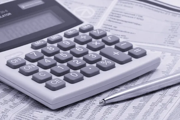 Newspaper with pen and calculator — Stock Photo, Image