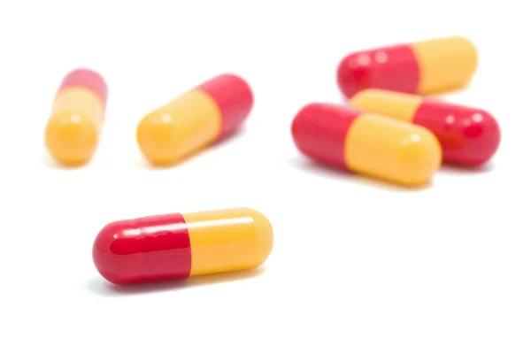 Czerwone i żółte kapsułki tabletki na białym tle — Zdjęcie stockowe