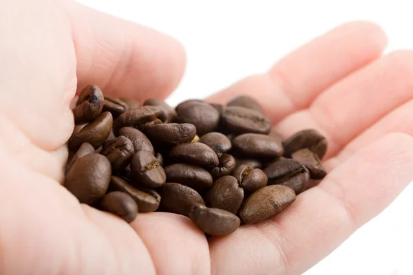 Рука тримає кавові зерна ізольовані — стокове фото