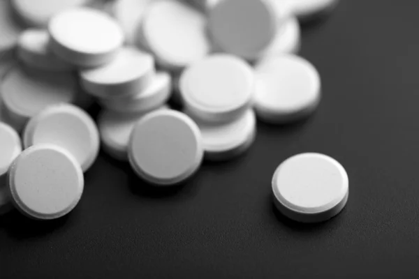 Vita piller över svart bakgrund — Stockfoto
