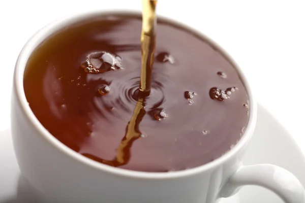 Versare il tè in una tazza bianca isolata — Foto Stock