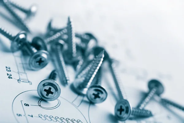 Metal screws over technical drawing — Stock Photo, Image