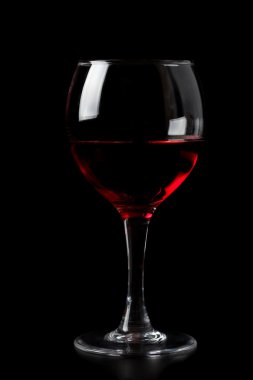 Red wine in glass isolated on black clipart