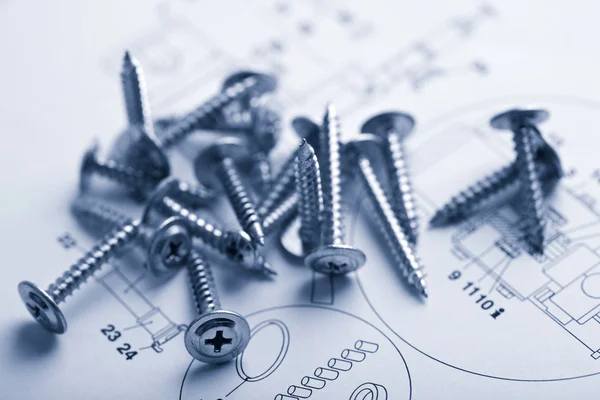 Metal screws over technical drawing — Stock Photo, Image