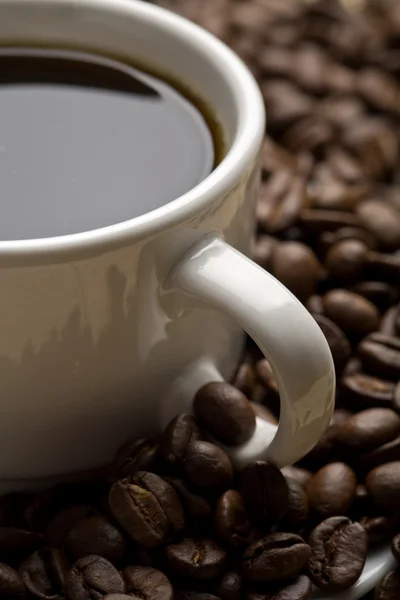 Weiße Tasse Kaffee und Kaffeebohnen — Stockfoto