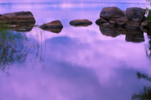 Lake with stones at sunset — Stock Photo, Image