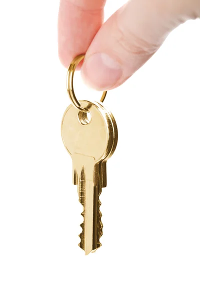 Palce trzymając złote klucze na białym tle — Zdjęcie stockowe