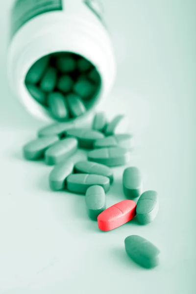 Groene pillen met een rode pil — Stockfoto