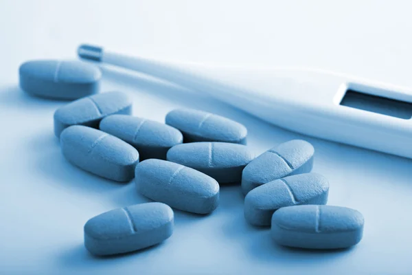 Pílulas de prescrição e termômetro — Fotografia de Stock
