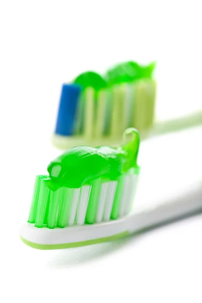 Tandborstar med gröna tandkräm — Stockfoto