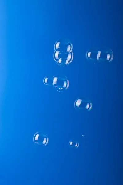 Bolhas de sabão sobre fundo azul — Fotografia de Stock