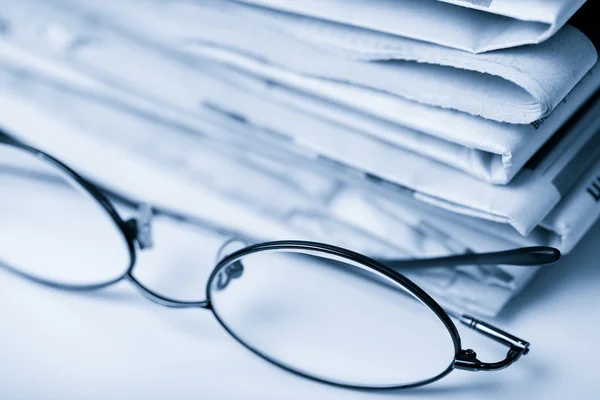 Newspapers and glasses toned blue — Stock Photo, Image