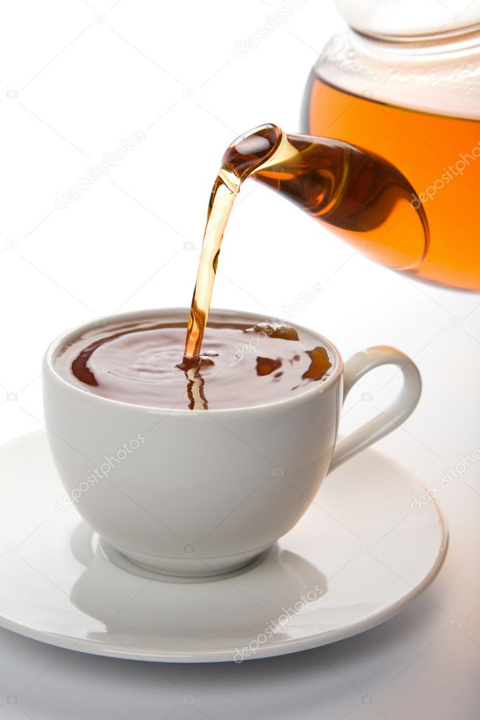 Tea pouring into white cup isolated