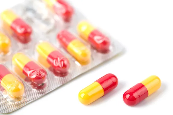 Piros és sárga kapszula tabletták a fólia — Stock Fotó