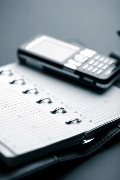 Organizador e telefone celular — Fotografia de Stock