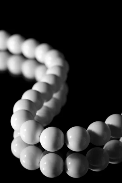 Fekete felett elszigetelt fehér gyöngyök — Stock Fotó