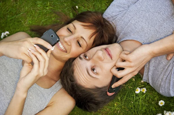 Νεαρό ζευγάρι με τα κινητά τηλέφωνα — Φωτογραφία Αρχείου