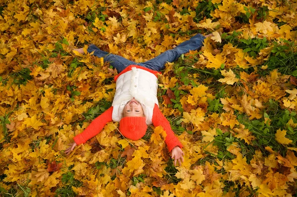 Carina bambina sdraiata in foglie d'autunno — Foto Stock