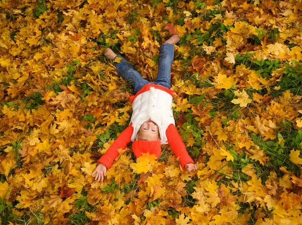 可爱的小女孩躺在秋天的树叶 — 图库照片