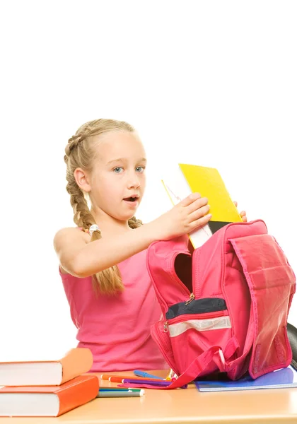Schoolgirl packing her backpack — Stock Photo, Image