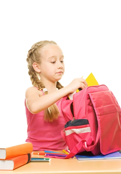 Schoolgirl packing her backpack — Stock Photo, Image