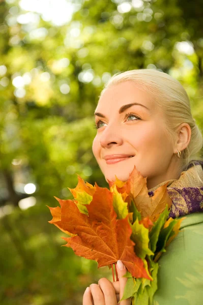 Vrouw met herfstbladeren — Stockfoto