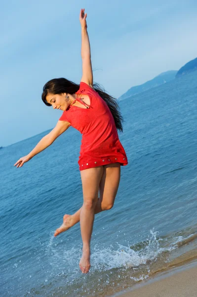 Молода жінка стрибає в море — стокове фото