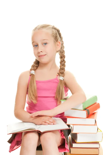 Malá školačka, sedící na knihách — Stock fotografie