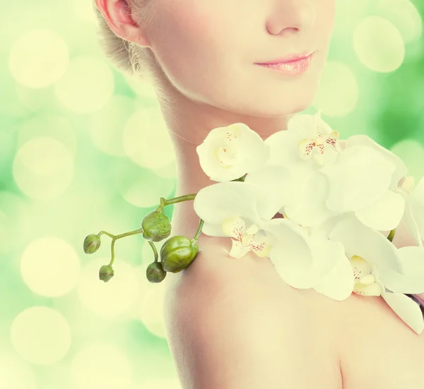 Ung kvinna med vit orkidé blomma — Stockfoto