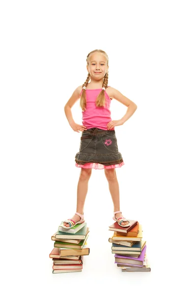 Śmieszne uczennica stojący na książki — Zdjęcie stockowe