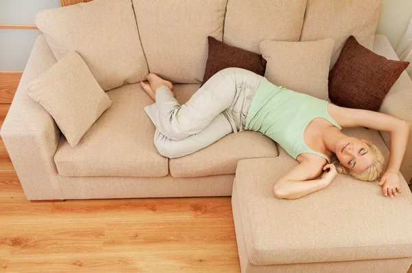 Schöne junge Frau entspannt sich auf einem Sofa — Stockfoto