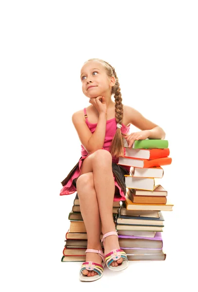 Little schoolgirl sitting on books — Stock Photo, Image