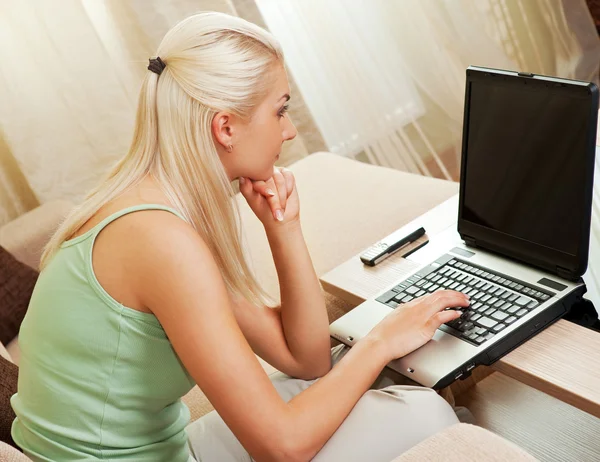 Giovane donna che lavora su un computer portatile a casa — Foto Stock